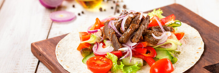 Tacos with Vegetables and Meat against a light wood Background. Selective Focus.