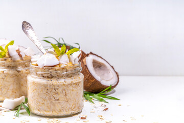 Breakfast overnight oatmeal oats with coconut milk and fresh coconut pieces. Diet healthy food,...