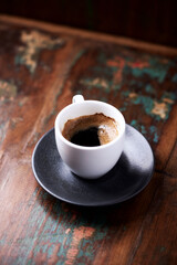 Cup of coffee on rustic wooden background. Close up.