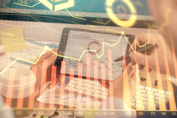Double exposure of man's hands holding and using a phone and financial chart drawing. Market analysis concept.