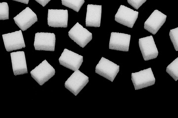 Natural white sugar cubes isolated on black background