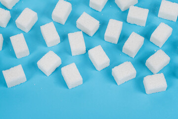 Natural white sugar cubes isolated on blue background