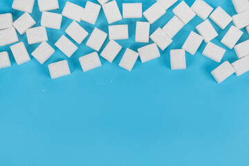 Natural white sugar cubes isolated on blue background
