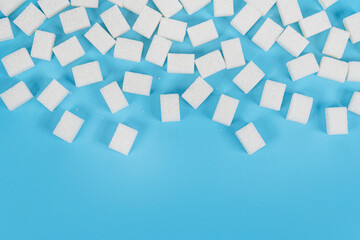 Natural white sugar cubes isolated on blue background