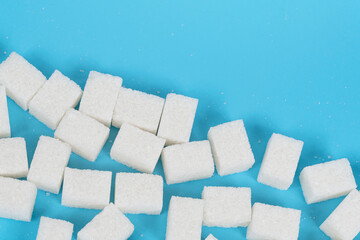 Natural white sugar cubes isolated on blue background