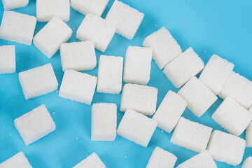 Natural white sugar cubes isolated on blue background
