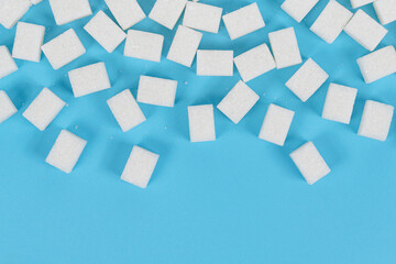 Fototapeta na wymiar Natural white sugar cubes isolated on blue background