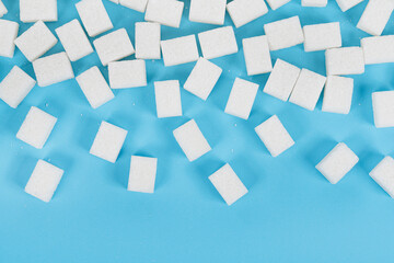 Fototapeta na wymiar Natural white sugar cubes isolated on blue background