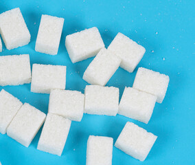 Natural white sugar cubes isolated on blue background