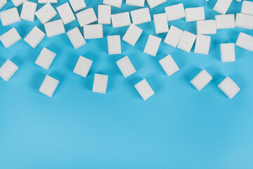 Natural white sugar cubes isolated on blue background