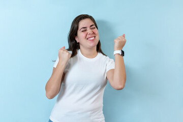 Fototapeta premium Excited girl on light blue background.