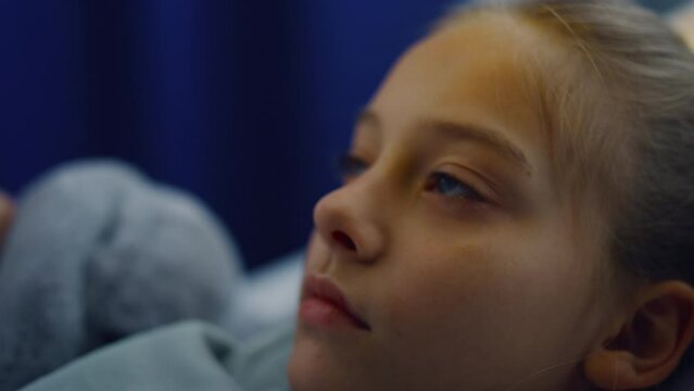 Closeup girl medical examination in hospital unit. Upset little patient in ward.