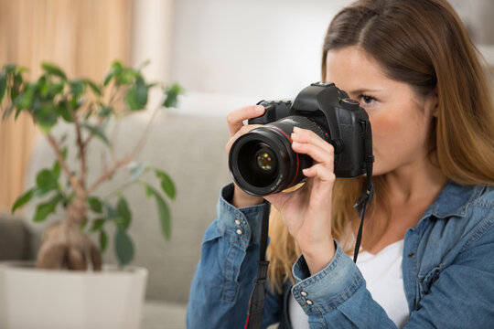 young woman using modern dslr camera in the home