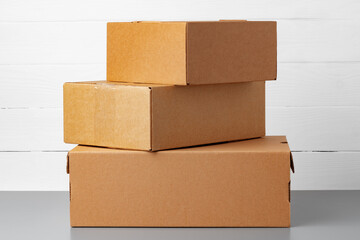 Group of cardboard boxes against white wooden wall