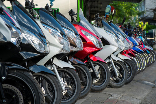 Motorcycles parked in a row on sidewalk.