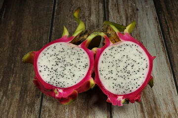 Pile of organic dragon fruit on the wooden table. Famous tropical fruit in Asia market. High vitamin and fiber concept.