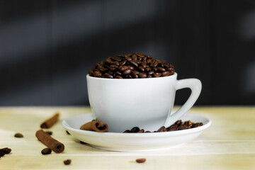 Obraz premium White cup and saucer with fragrant coffee beans