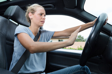 stressed female driver blowing car horn