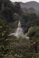 White buddhist church at Wat tham potisat or Potisat cave temple built in the middle of the mountain. Selective focus.