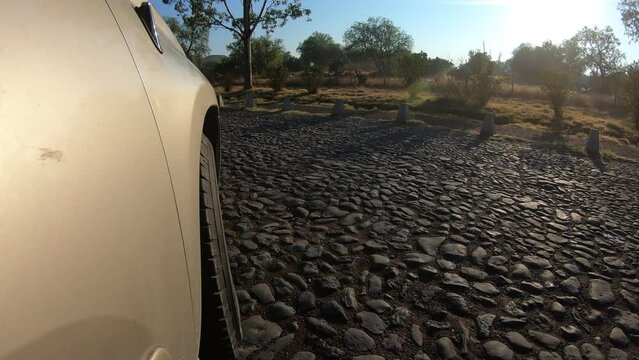 A close top of a car's wheel speeding on a mountain street in Teotihuacan, Mexico