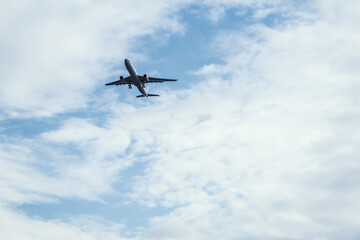 Airplane in the bright blue sky. Air transportation trip. The plane is taking off. Flight of traveling abroad.