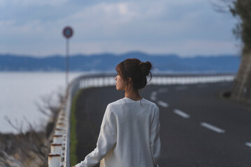 Fototapeta premium 夕暮れの海岸線を歩く女性