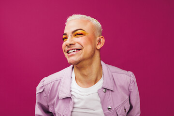 Queer man smiling cheerfully in a studio - obrazy, fototapety, plakaty