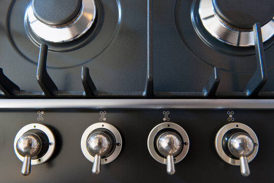 A kitchen stove with gas burners and control knobs. 