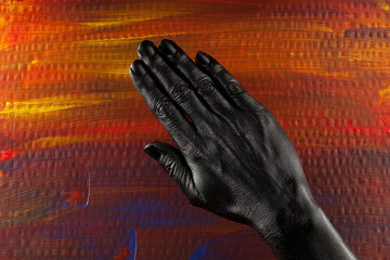 The outside of the hand painted with black paint. A palette of warm and cool colors in the...