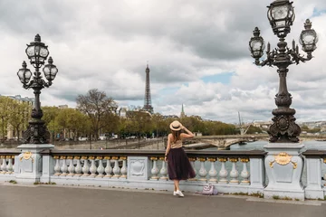 Stickers pour porte Pont Alexandre III Pretty faceless girl in hat admiring the view from pont Alexandre III to Eiffel Tower. Old forged lanterns on the Alexander 3 bridge. Woman travelling by Paris. Wanderlust. Copy space.
