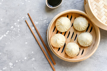  Bamboo steamers with tasty baozi dumplings, chopsticks and bowl of sauce. Chinese food delivery
