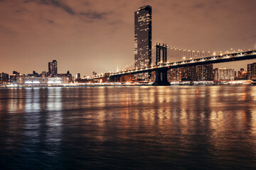 Fototapeta na wymiar manhattan bridge and new york city skyline at night by the bay