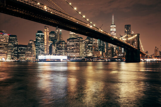 Fototapeta brooklyn bridge and new york city skyline at night by the bay