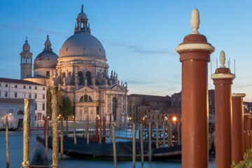 Venezia. Veduta di Santa Maria della Salute con Gondole ormeggiate e pali dai giardinetti, al tramonto.