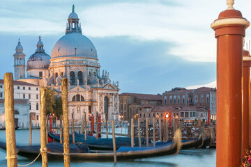 Fototapeta na wymiar Venezia. Veduta di Santa Maria della Salute con Gondole ormeggiate e pali dai giardinetti, al tramonto.