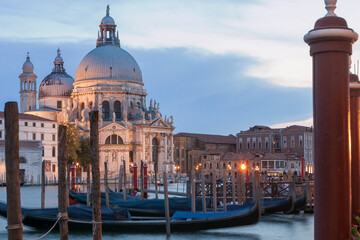 Obraz na płótnie Canvas Venezia. Veduta di Santa Maria della Salute con Gondole ormeggiate e pali dai giardinetti, al tramonto.