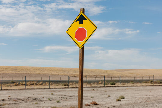 Stop Sign ahead, a yellow sign and red circle with arrow, roadside safety sign. 