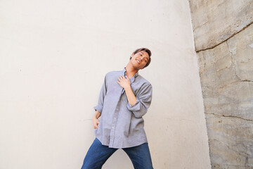 Obraz premium Man dancing and smiling by concrete wall
