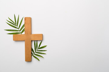 Palm branches and cross on white background, top view. Palm Sunday concept