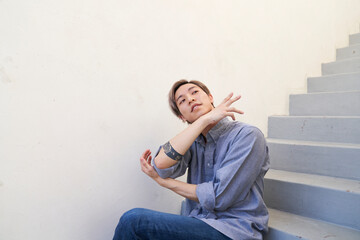 Man sitting on stairs with arm to chin