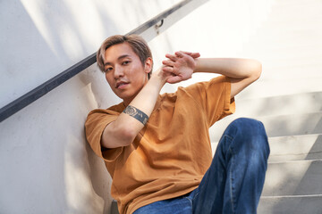 Man sitting on stairs with hands touching