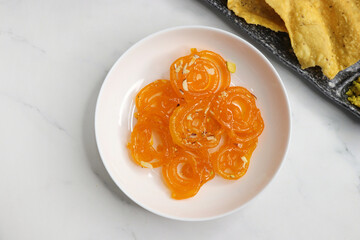 Popular Indian sweet Jalebi and Fafda served with Sambhara. Gujarati snack is mostly eaten during Indian Festivals such as, Gudi Padwa, Dussehra, Eid, Diwali, Mahashivratri, Holi. with Copy space. 