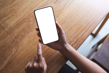 Top view mockup image of a woman holding mobile phone with blank desktop screen