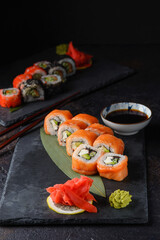 Philadelphia roll sushi with salmon, avocado, cream cheese. Sushi menu. Japanese food. Dark photography. Close up - 495876266