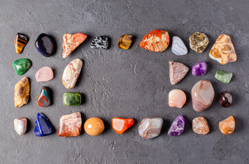 Mineral stones on a black concrete background. The concept of using minerals in astrology and...
