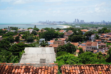 Panoramic view of historical city of Olinda, UNESCO World Heritage Site. In background high rise buildings of the capital of state Pernambuco, Brazil. - obrazy, fototapety, plakaty