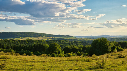 A sunny day in the Saarland with a view over meadows into the valley.