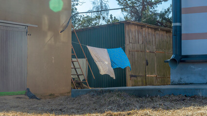 Bedding sheets drying on the clothesline outside. Lens flare. Bed linen drying on a clothes line in...