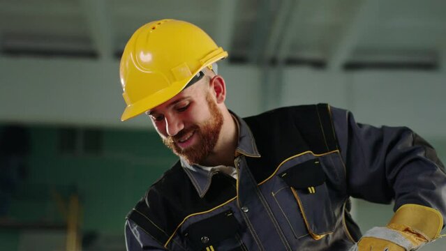 Closeup to the camera smiling large a construction worker man with safety helmet and uniform he working at construction site and enjoy the moment