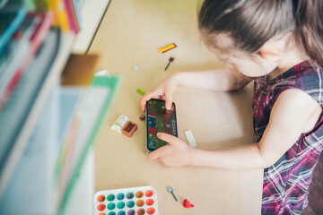 Little girl playing mobile games on her phone.	